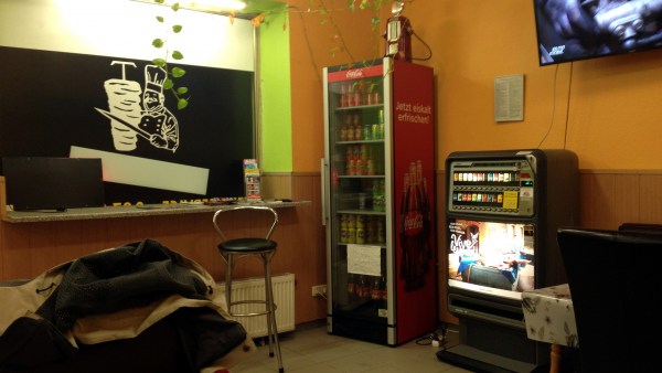 Getränkekühlschrank, Zigarettenautomat, Fenster, Fernseher im Gastraum der Pizzeria Antalya