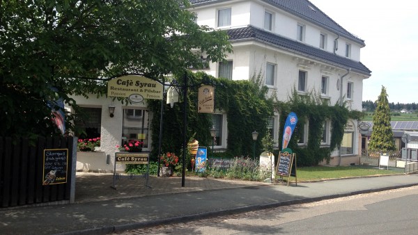 Weißes Haus im Einklang mit der Natur, umwachsen von saftigem Grün