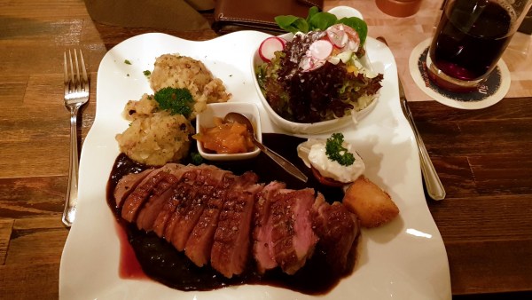 Entebnrustfilet, zart rosa gegrillt, auf fruchtiger Plaumensauce, angerichtet mit Kartoffelstampf, Apfelchutney und Salat