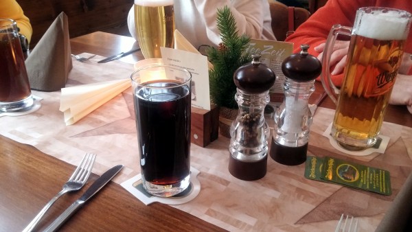 Gedeckter Tisch mit Besteck, Cola, Bier und Pfeffer- und Salz-Streuer