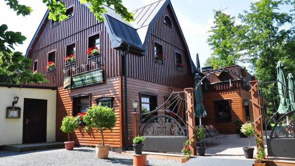 Restaurant: Großes Haus mit Holzfassade und Terrasse