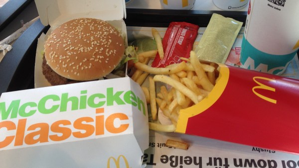 McDonalds Menü mit Burger, Pommes, Hühnchen-Burger, Ketchup und Majonäse auf Tablett
