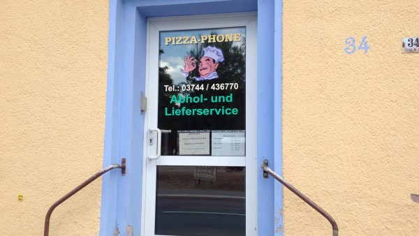 Eingangstür mit vielen Infos zum Pizza-Phone und Geländer