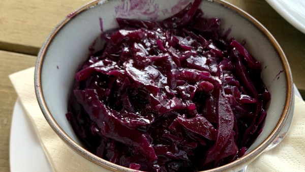Fertig zubereitetes Rotkraut in einer weißen Schüssel mit Goldrand auf Teller mit Serviette