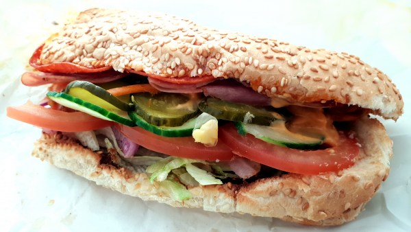 Salami-Sandwich im Sesam-Brot mit Gurke und Tomate