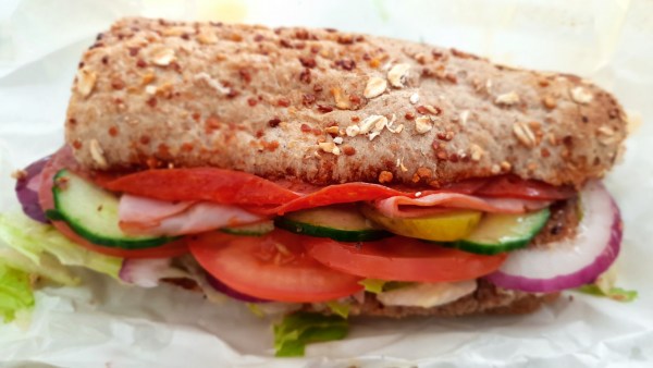 Salami-Sandwich im Cheese-Oregano-Brot mit Schinken, Tomate, Gurke, Zwiebeln und Salat