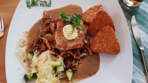 Essen auf Teller: Steak mit Kräuterbutter und Petersilie, dazu Pfifferlinge, Weißkraut , Gurken-Stücke und Kartoffel-Röstis